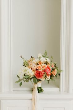 a bouquet of flowers sitting on top of a mantle