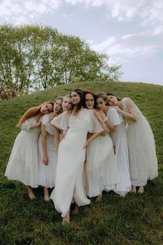 a group of women standing next to each other on top of a lush green field