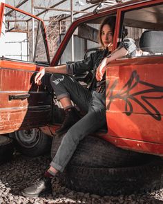 a woman sitting on top of an old truck