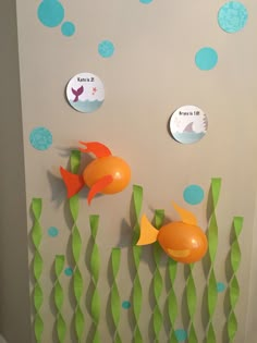 some paper fish are hanging on the wall