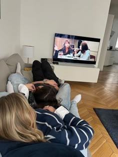 two people sitting on a couch watching tv