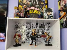 anime figurines are displayed on shelves in a room with comic books and posters