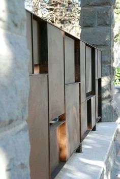 an outdoor area with stone walls and metal panels on the outside wall, along with steps leading up to it