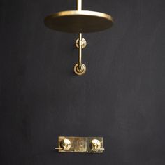 a black wall with a gold light fixture