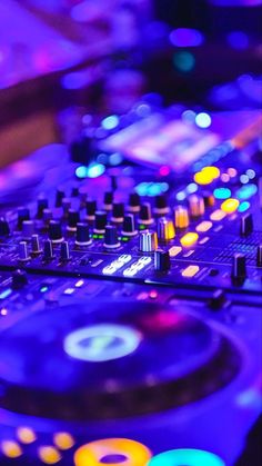 a dj's turntable with colorful lights in the background