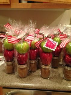 apples wrapped in cellophane with candy canes and bows are sitting on top of each other