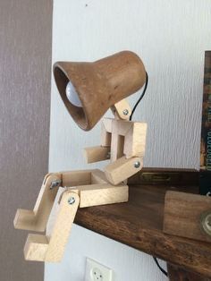 a desk lamp made out of wooden blocks on top of a shelf next to a bookshelf