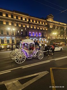 a horse drawn carriage on a city street at night