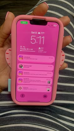 a person holding a pink cell phone in their hand