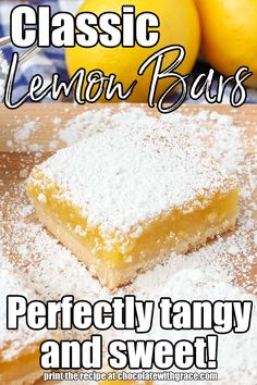 two lemon bars on a cutting board with powdered sugar and fresh lemons in the background