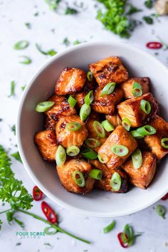 a white bowl filled with tofu and green onions