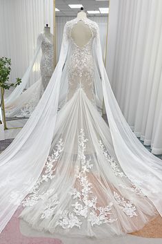 a white wedding dress on display in front of a mirror