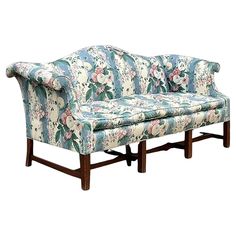 an upholstered floral couch with wooden legs