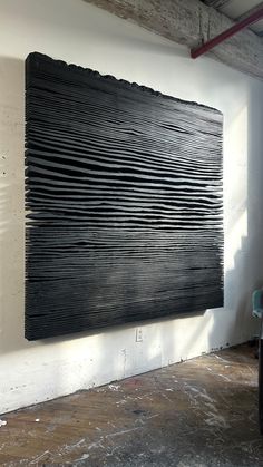 a large black piece of art hanging on the wall