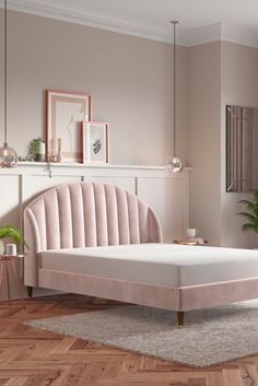 a white bed sitting on top of a wooden floor next to a wall mounted clock