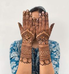 a woman holding her hands up with hendi tattoos on it