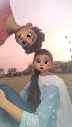 two dolls are sitting in the grass with one doll on top of the other head