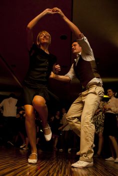 two people are dancing on a wooden floor