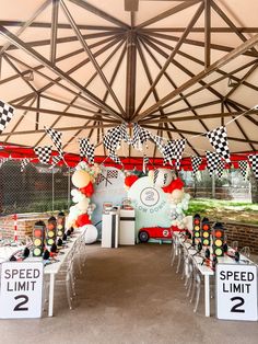 an outdoor event with checkered flags and speed limit signs on the side of the tent