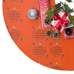 an orange heart shaped table with presents and decorations on it, along with pine cones