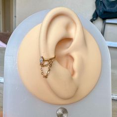 a fake ear with a ring attached to it on top of a plastic display stand