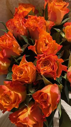 an arrangement of orange roses in a vase