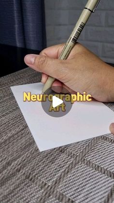 someone holding a pen and writing on paper with the word neurographic art