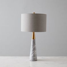 a marble table lamp with a grey shade