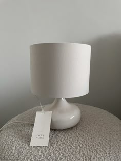 a white table lamp with a price tag on it