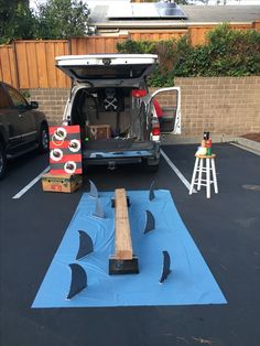 the back end of a van parked in a parking lot with its trunk open and tools inside