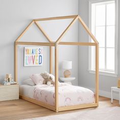 a child's bed with a wooden frame and canopy