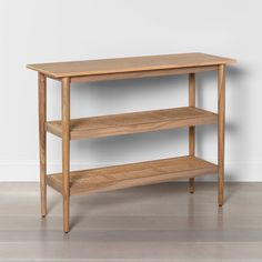 a wooden shelf sitting on top of a hard wood floor next to a white wall