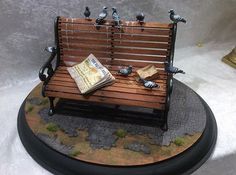 a wooden bench with birds sitting on it and a newspaper laying on top of it