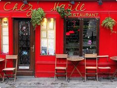 a red restaurant with tables and chairs outside