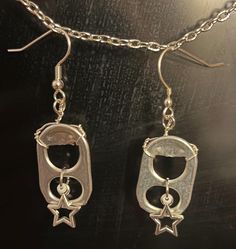 two pairs of silver earrings hanging from chains