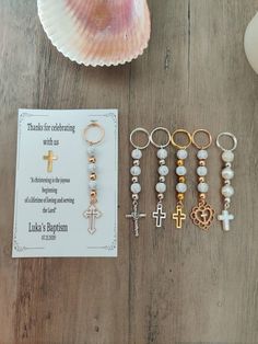 a table topped with lots of different types of jewelry next to a card and seashell