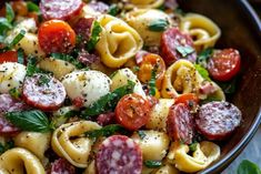 a bowl filled with pasta and vegetables on top of a table