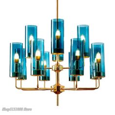 a chandelier with blue glass shades and gold metal tubes hanging from the ceiling