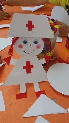 a child's paper doll made to look like a nurse on an orange table