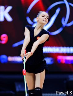 a woman in black dress holding a tennis racquet