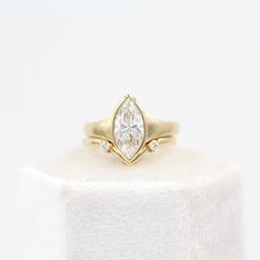 a yellow gold ring with a pear shaped diamond