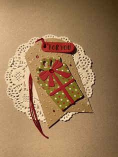 an ornament shaped like a gift card on a doily