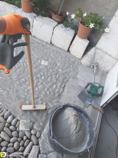 there is a cement paver and a shovel on the ground next to some rocks