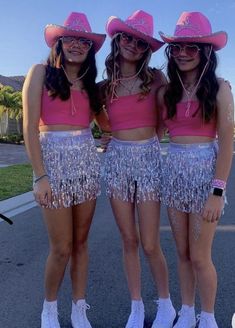 three girls wearing pink hats and fringe skirts