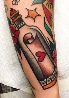 a tattoo with a bottle and flowers on it