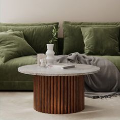 a living room with green couches and a round coffee table in the center area