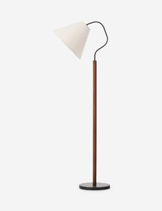 a wooden floor lamp with a white shade on the top and a black stand underneath it