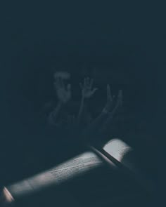 an open book sitting on top of a table next to a person's hand