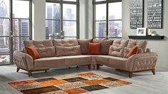 a living room with large windows and a sectional couch in front of a rug on the floor