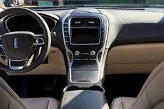 the interior of a car with beige leather and black trims, including steering wheel